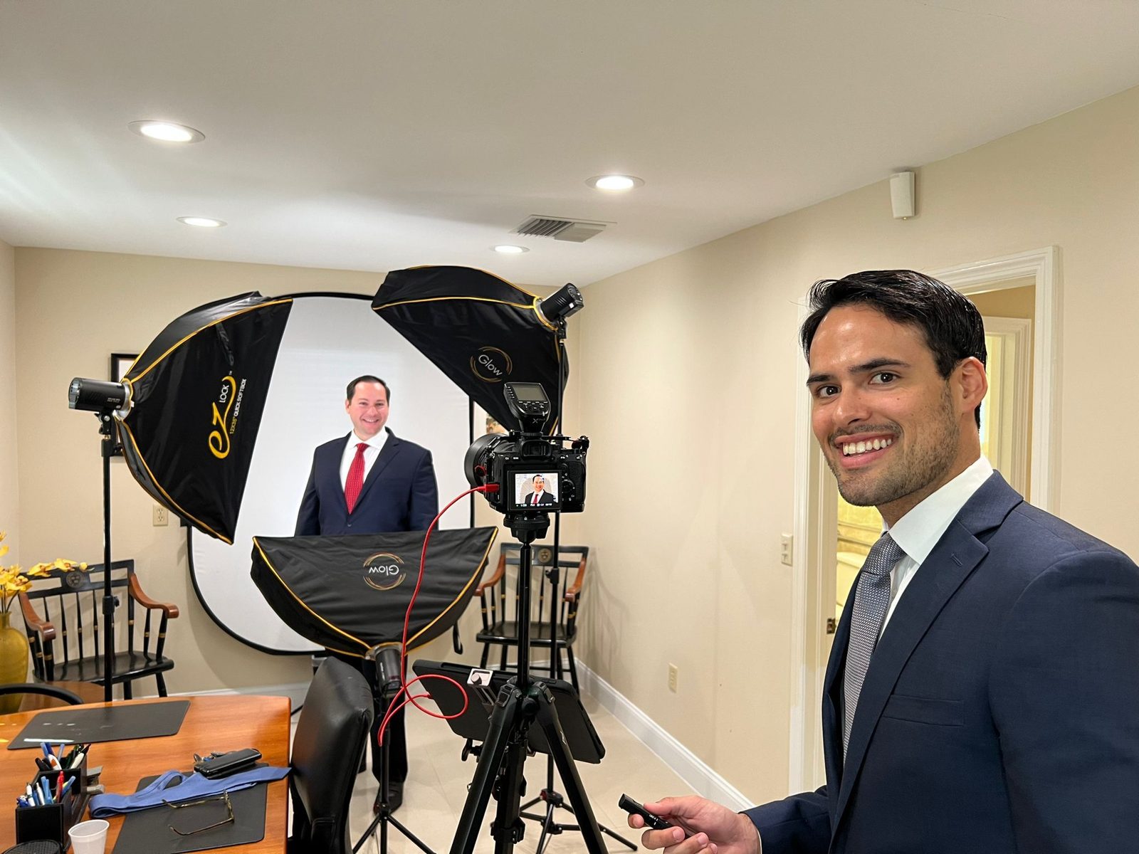 Smiling client beside the backdrop at an in-home headshot session