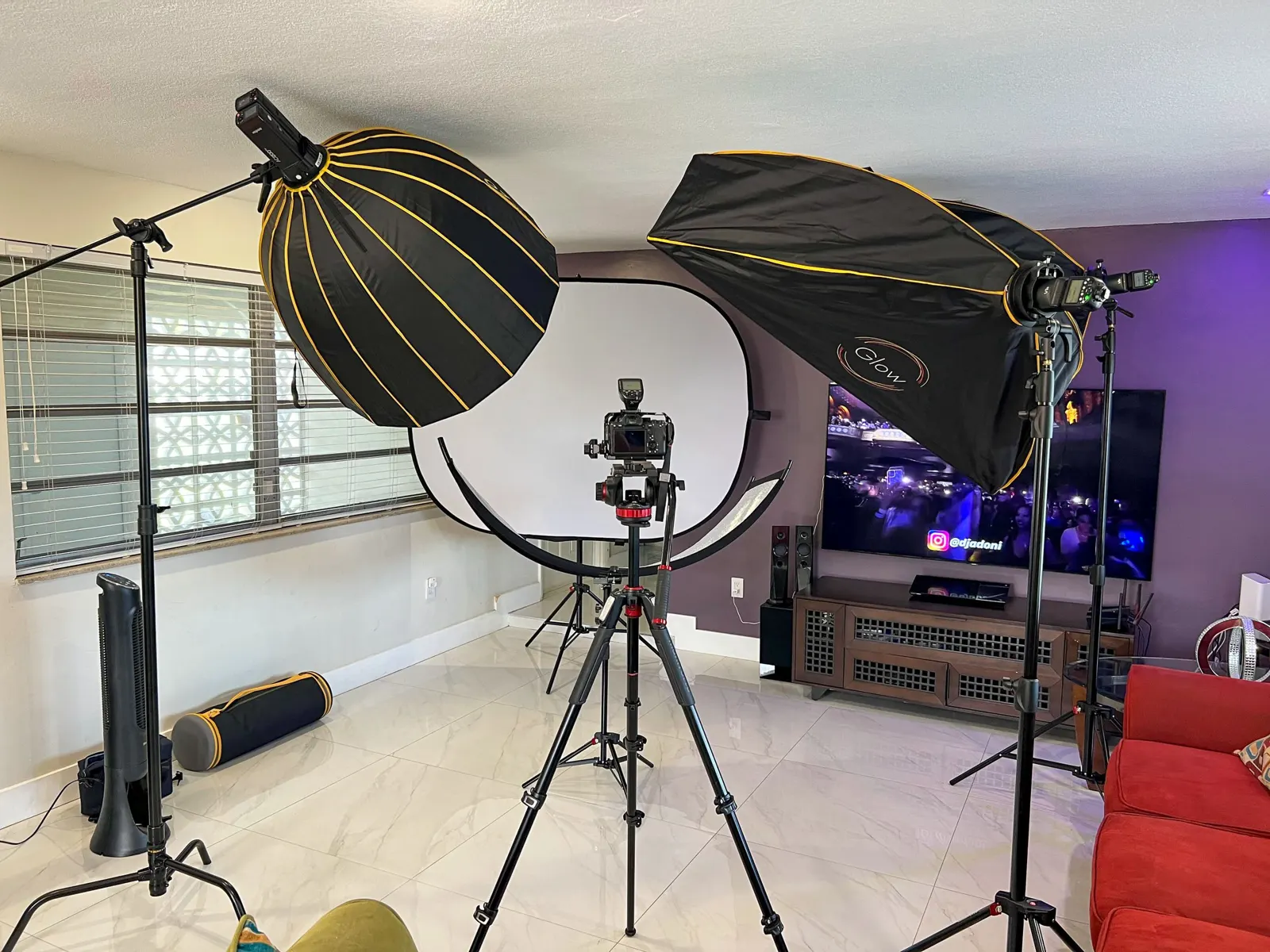 Lights and a camera set up for a shoot in a client's living room