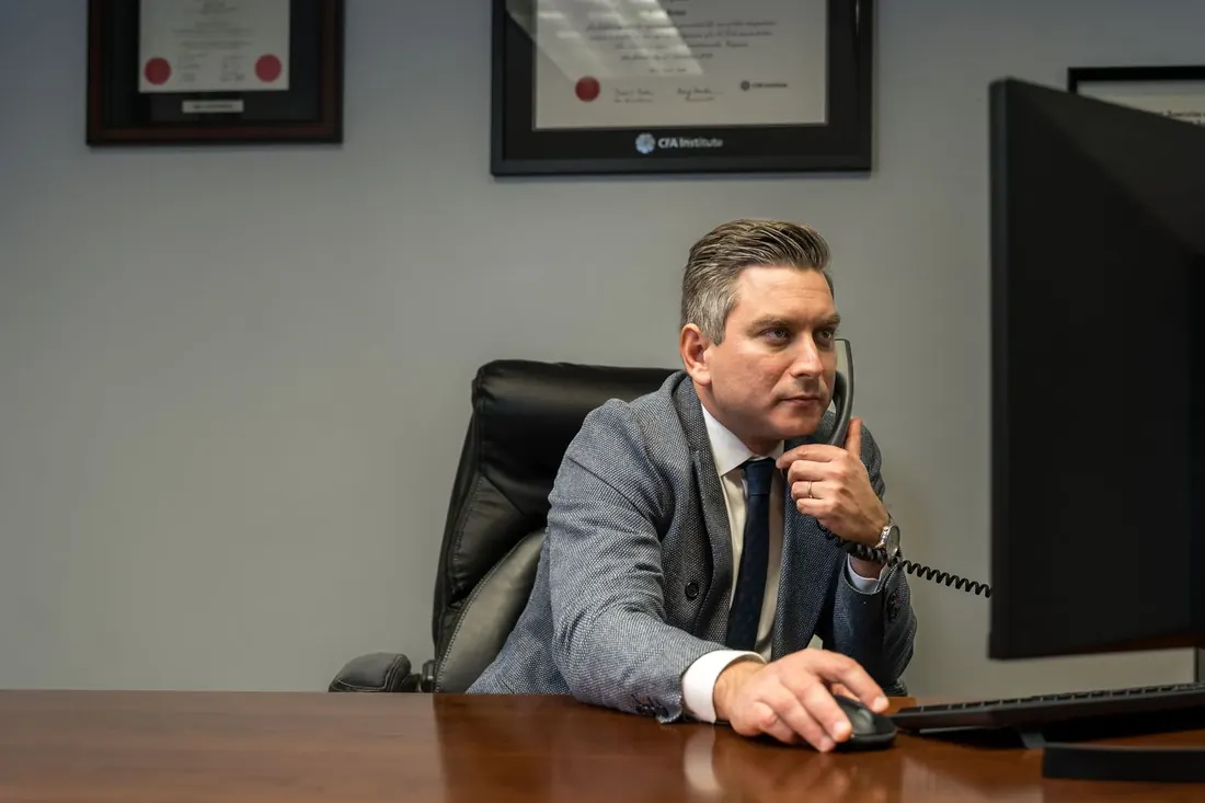 A business owner on the phone at his desk, photographed on location for his company