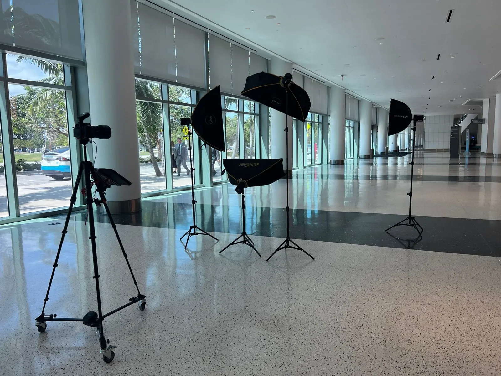 Camera and lighting rigged in a bright glass walled lobby