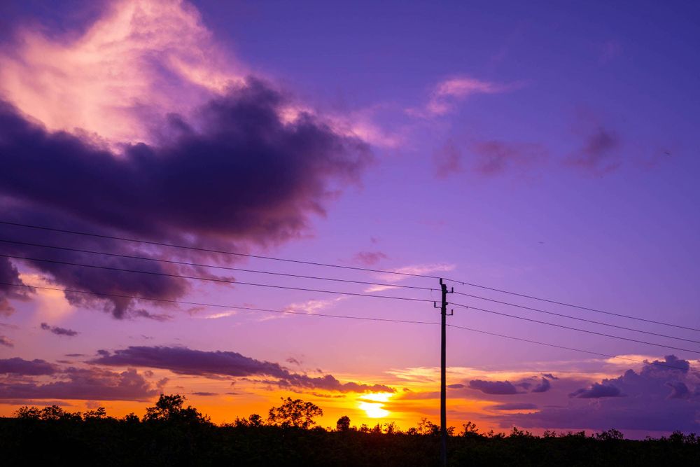 Purple and orange sunset over power lines