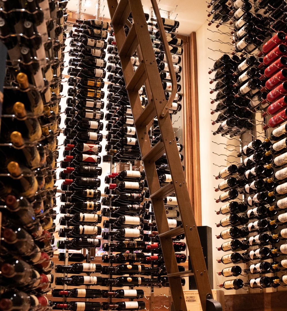 Rows of bottled wine on a retail display wall