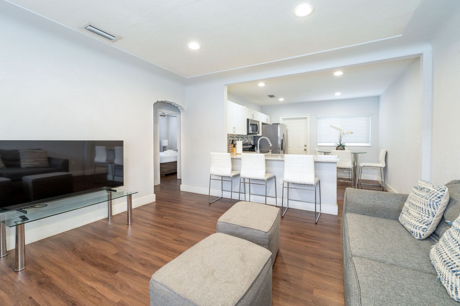 Open-concept living room and kitchen with wood flooring and bar seating