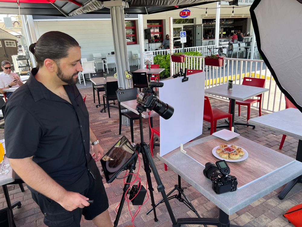 Our photographer checking a camera set up over a plated dish on a restaurant patio