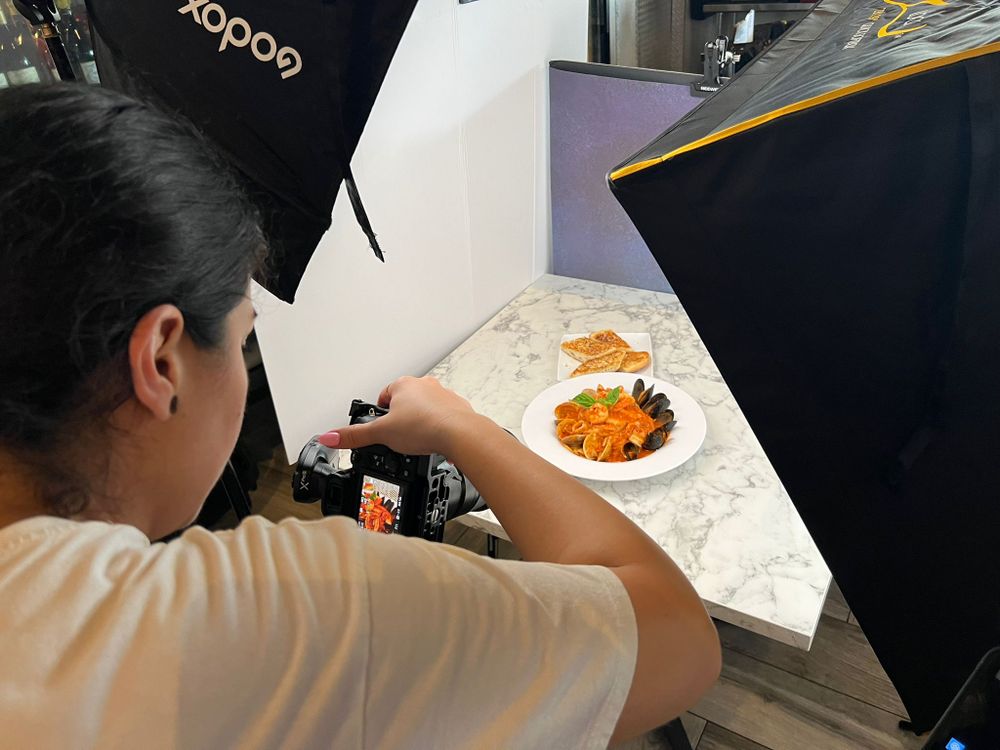 Our photographer framing a plated dish between two softboxes in a restaurant kitchen