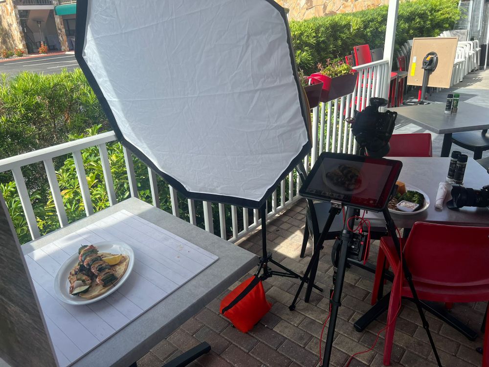 A softbox lighting a plated dish on an outdoor patio table