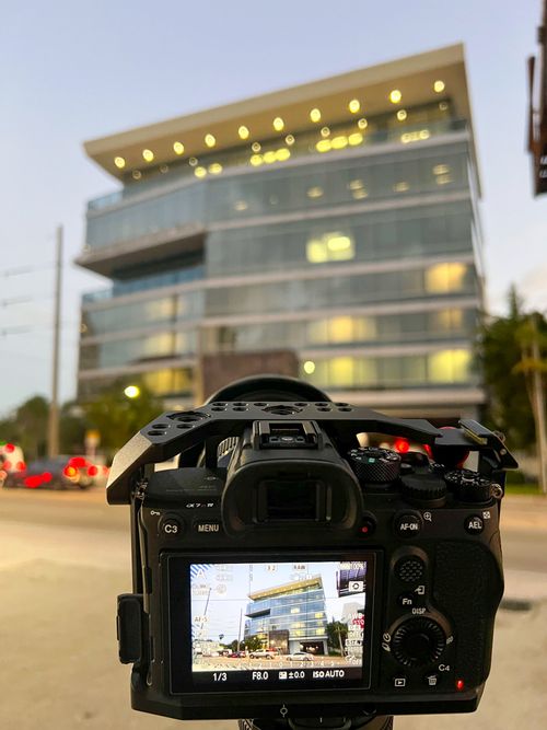 Camera live view showing a lit office building exterior at dusk