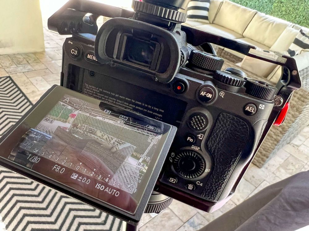 Close-up of a mirrorless camera flip screen on a tripod outdoors
