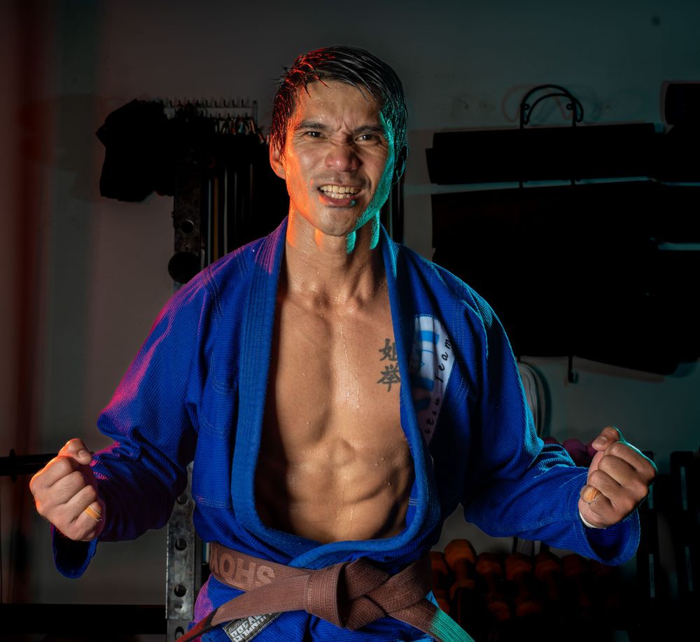 Editorial personal brand portrait in a jiu-jitsu gi under colored studio lighting