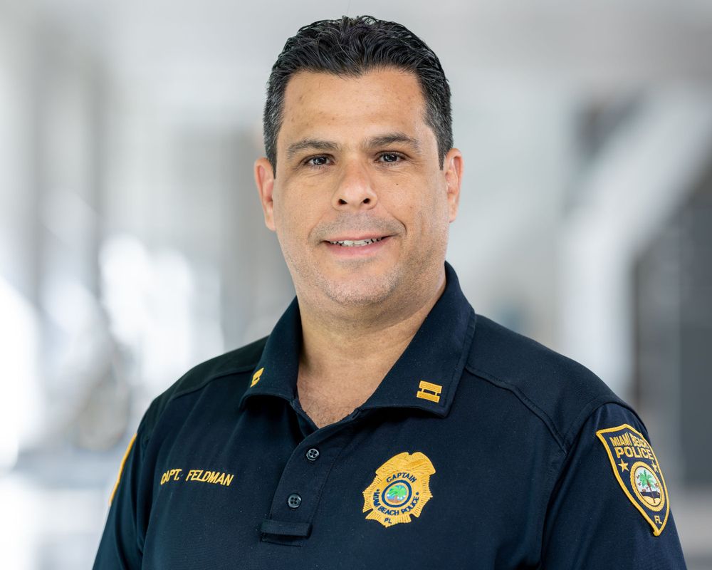 On-location headshot inside a police department, uniform with department patches