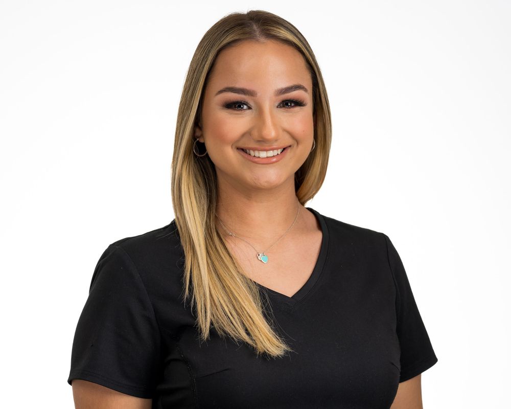 Studio headshot on white, black v-neck top