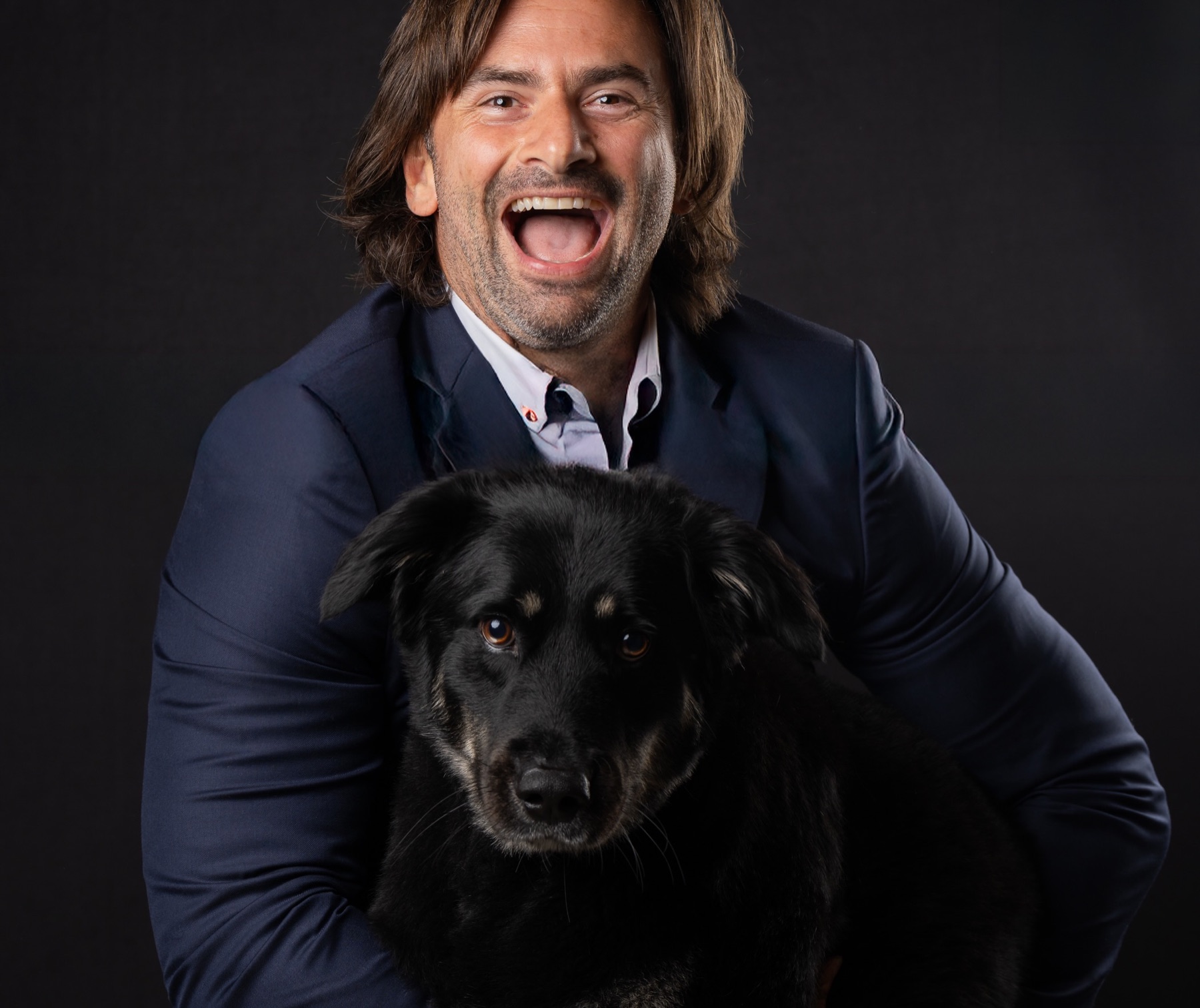 Studio headshot with the client's dog, dark backdrop