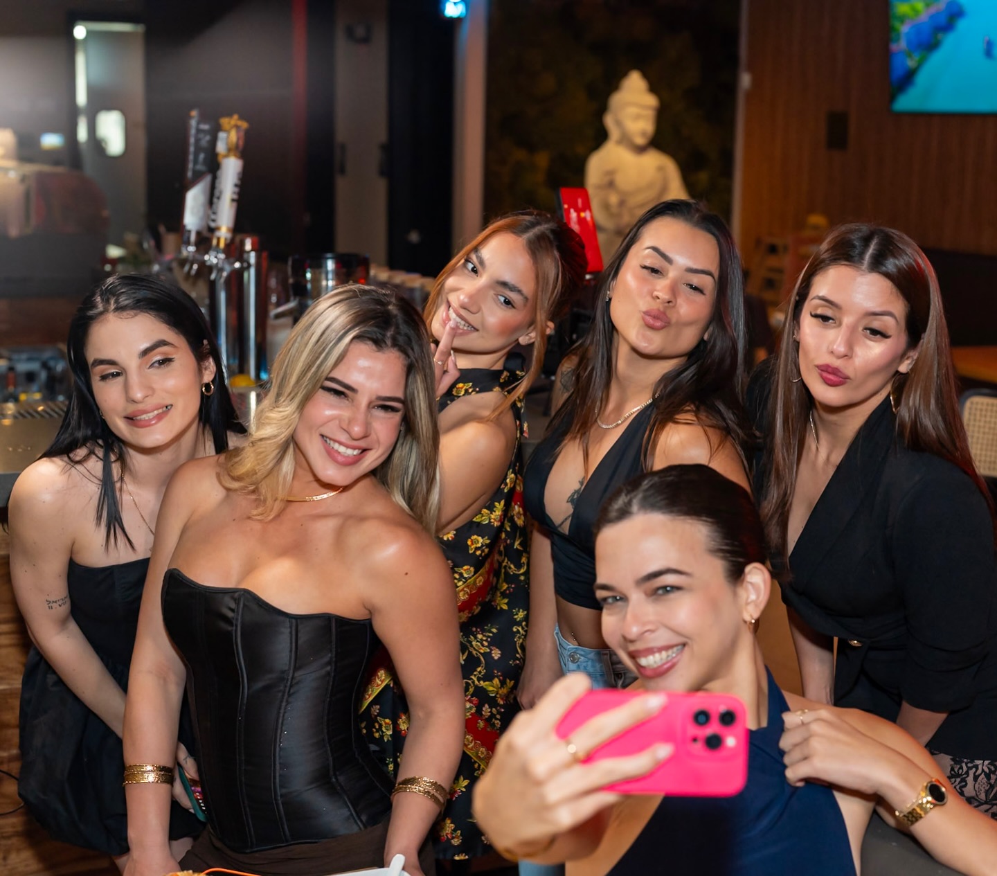 Group of friends taking a selfie together at a bar